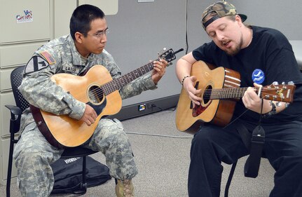 Volunteer instructor Christian Lee (right) works with Spc. Hyson Largo Nov. 12 during a therapeutic music group for Soldiers at Brooke Army Medical Center