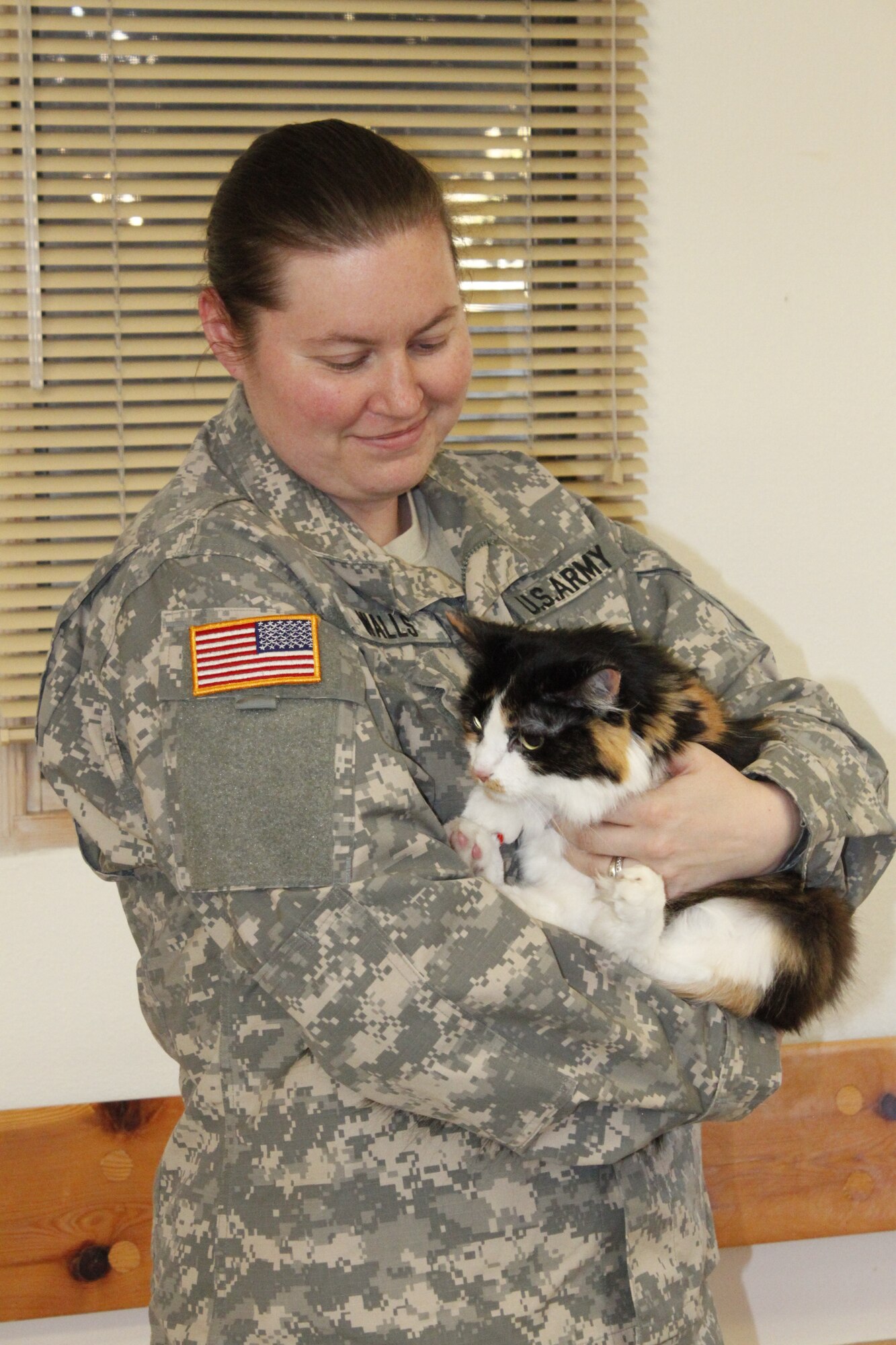 U.S. Army Staff Sgt. Kimberly Walls holds her cat Miaka at the Kirtland Animal Treatment Facility. Walls, a veterinary technician, said learning she could serve her country as a veterinary technician was a "dream come true." (Photo by Meredith Mingledorff) 
