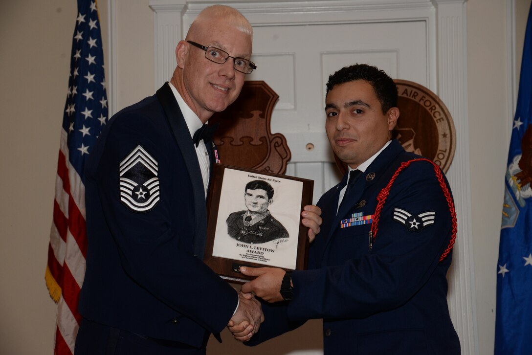 U.S. Air Force Senior Airman Jesse Justiniano, 31st Intelligence Squadron, receives the John L. Levitow Award for the Senior Master Sgt. David B. Reid Airman Leadership School Class 15-1, from Chief Master Sgt. Scott Thomsen, 20th Operations Group superintendent, at Shaw Air Force Base, S.C., Nov. 21, 2014. The Levitow Award is given to the graduate with the highest average of instructor and student points, and is the highest award in enlisted professional military education. (U.S. Air Force photo by Airman 1st Class Jonathan Bass/Released)