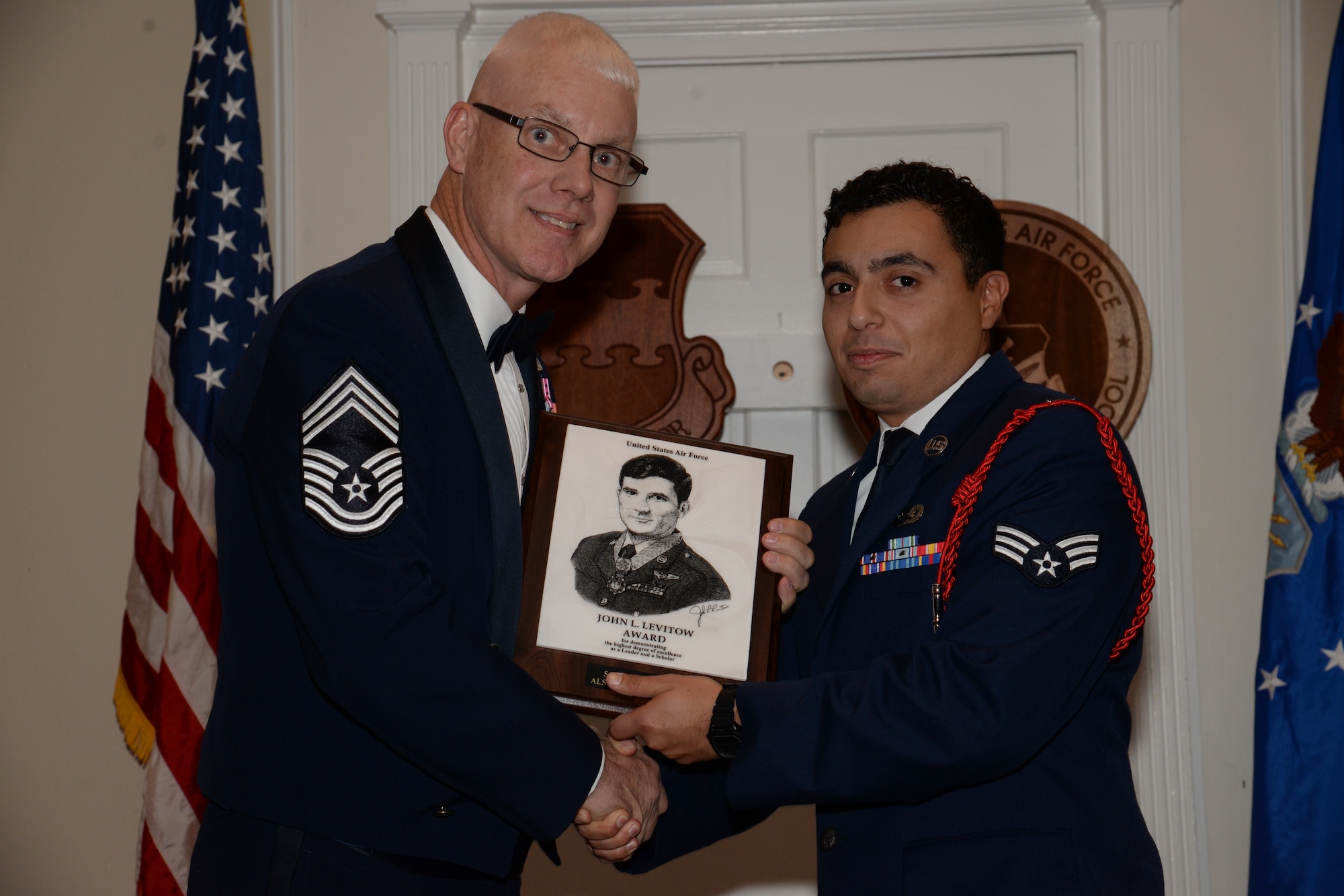 U.S. Air Force Senior Airman Jesse Justiniano, 31st Intelligence Squadron, receives the John L. Levitow Award for the Senior Master Sgt. David B. Reid Airman Leadership School Class 15-1, from Chief Master Sgt. Scott Thomsen, 20th Operations Group superintendent, at Shaw Air Force Base, S.C., Nov. 21, 2014. The Levitow Award is given to the graduate with the highest average of instructor and student points, and is the highest award in enlisted professional military education. (U.S. Air Force photo by Airman 1st Class Jonathan Bass/Released)