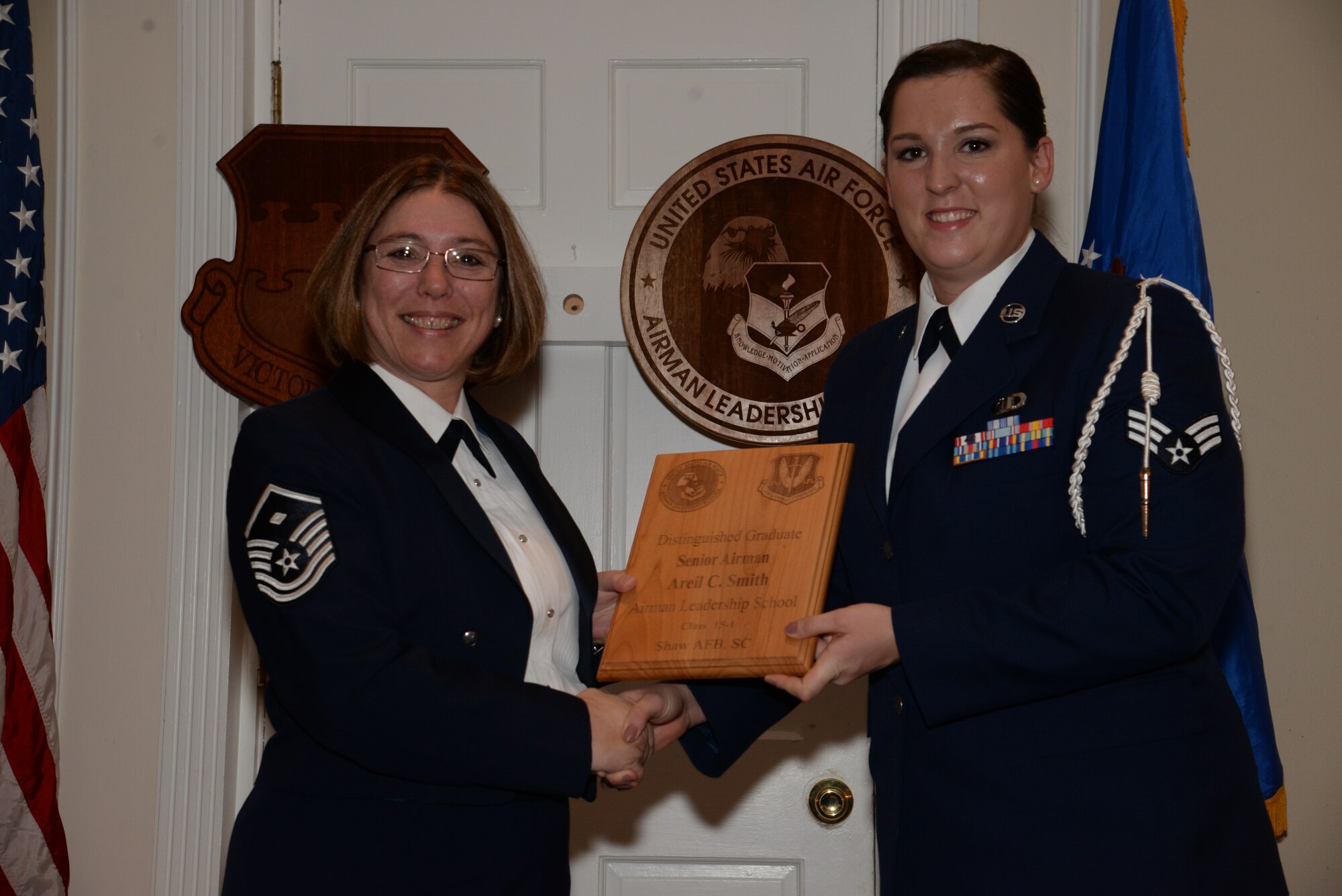 U.S. Air Force Senior Airman Areil Smith, 20th Operations Support Squadron, receives a distinguished graduate award for the Senior Master Sgt. David B. Reid Airman Leadership School Class 15-1 from Master Sgt. Rhonda Roman, 20th Component Maintenance Squadron first sergeant, at Shaw Air Force Base, S.C., May 15, 2014. The distinguished graduate awards are given to the top 10 percent of the class for total point accumulation. (U.S. Air Force photo by Airman 1st Class Jonathan Bass/Released)
