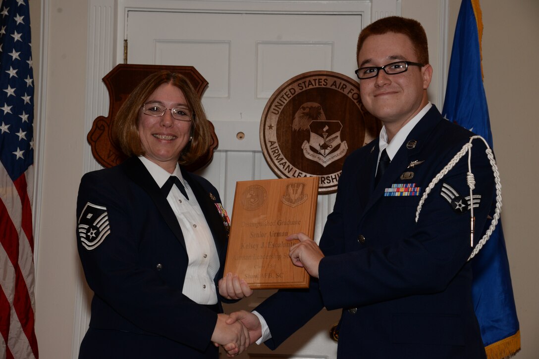 U.S. Air Force Senior Airman Kelsey Escalante, 5th Intelligence Squadron receives a distinguished graduate Award for the Senior Master Sgt. David B. Reid Airman Leadership School Class 15-1 from Master Sgt. Rhonda Roman, 20th Component Maintenance Squadron first sergeant, at Shaw Air Force Base, S.C., May 15, 2014. The distinguished graduate awards are given to the top 10 percent of the class for total point accumulation. (U.S. Air Force photo by Airman 1st Class Jonathan Bass/Released)