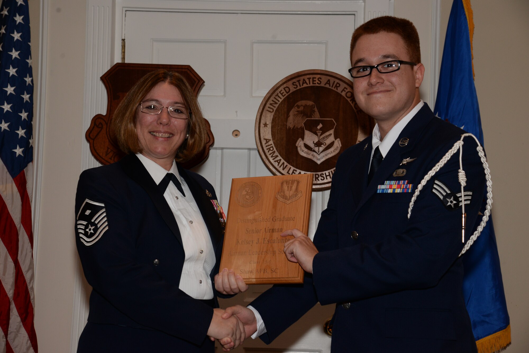 U.S. Air Force Senior Airman Kelsey Escalante, 5th Intelligence Squadron receives a distinguished graduate Award for the Senior Master Sgt. David B. Reid Airman Leadership School Class 15-1 from Master Sgt. Rhonda Roman, 20th Component Maintenance Squadron first sergeant, at Shaw Air Force Base, S.C., May 15, 2014. The distinguished graduate awards are given to the top 10 percent of the class for total point accumulation. (U.S. Air Force photo by Airman 1st Class Jonathan Bass/Released)