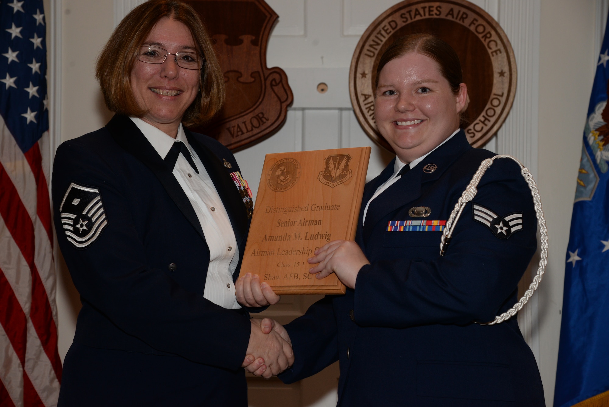 U.S. Air Force Senior Airman Amanda Ludwig, 3rd Intelligence Squadron, receives a distinguished graduate award for the Senior Master Sgt. David B. Reid Airman Leadership School Class 15-1 from Master Sgt. Rhonda Roman, 20th Component Maintenance Squadron first sergeant, at Shaw Air Force Base, S.C., May 15, 2014. The distinguished graduate awards are given to the top 10 percent of the class for total point accumulation. (U.S. Air Force photo by Airman 1st Class Jonathan Bass/Released)