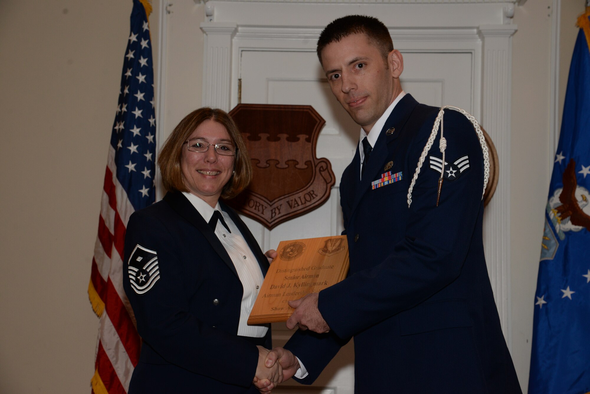 U.S. Air Force Senior Airman David Kyllingmark, U.S. Air Forces Central, receives a distinguished graduate award for the Senior Master Sgt. David B. Reid Airman Leadership School Class 15-1 from Master Sgt. Rhonda Roman, 20th Component Maintenance Squadron first sergeant, at Shaw Air Force Base, S.C., May 15, 2014. The distinguished graduate awards are given to the top 10 percent of the class for total point accumulation. (U.S. Air Force photo by Airman 1st Class Jonathan Bass/Released)