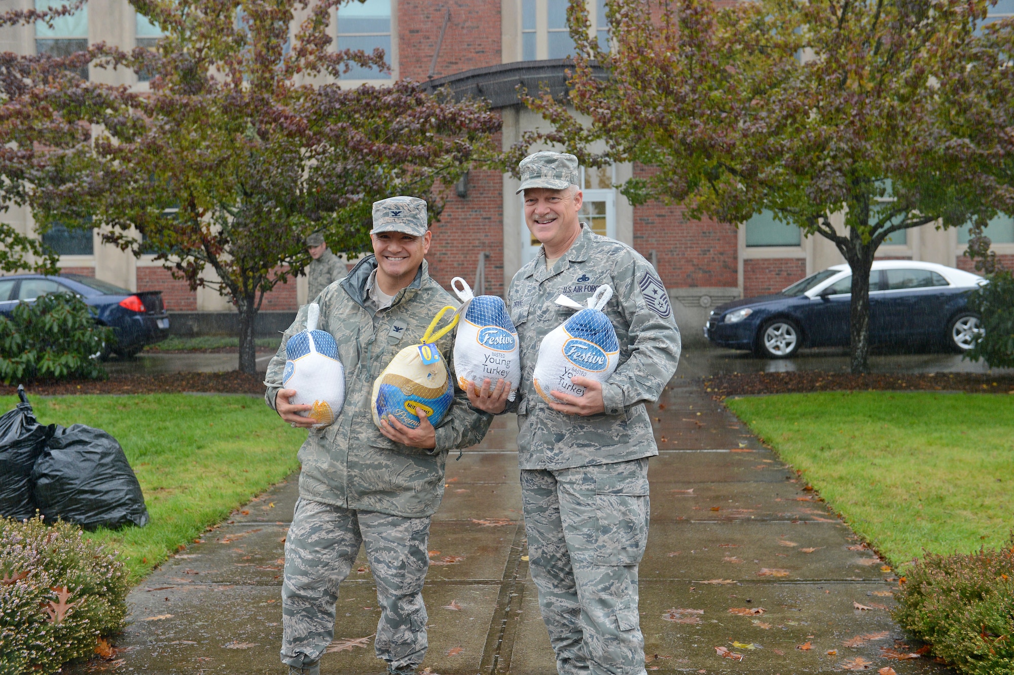 Col. David Kumashiro (left), 62nd Airlift Wing commander, and Chief Master Sgt. Gordon Drake, 62nd AW command chief, pose with donated frozen turkeys Nov. 25, 2014, during Operation Turkey Drop at Joint Base Lewis-McChord, Wash. More than 600 turkeys were donated this year and given to service members and their families stationed at JBLM. (U.S. Air Force photo/Airman 1st Class Keoni Chavarria)