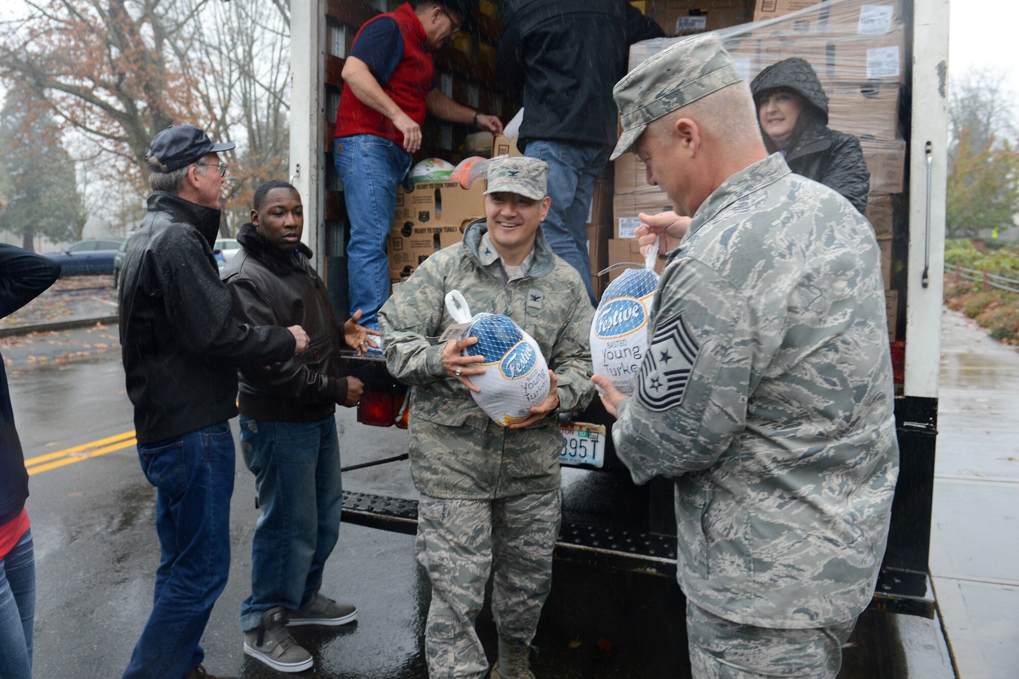 Col. David Kumashiro (middle), 62nd Airlift Wing commander, and Chief Master Sgt. Gordon Drake (right), 62nd AW command chief, unload frozen turkeys off of a truck Nov. 25, 2014, during Operation Turkey Drop at Joint Base Lewis-McChord, Wash. Operation Turkey Drop is a yearly event and turkeys are donated by local community members from Pierce County and local chambers. (U.S. Air Force photo/Airman 1st Class Keoni Chavarria)