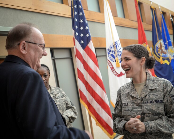 David Sparks, Air Force Mortuary Affairs Operations chaplain, greets Master Sgt. Nicole Zottola while she goes through the line for the Thanksgiving meal at the mortuary, Nov. 18, 2014, at Dover Air Force Base, Del. The annual meal is an opportunity for AFMAO leaders and Airmen to develop camaraderie and esprit de corps. Zottola is deployed to the mortuary from Pittsburgh International Airport Air Reserve Station, Pa.  (U.S. Air Force photo/Capt. Ray Geoffroy)
