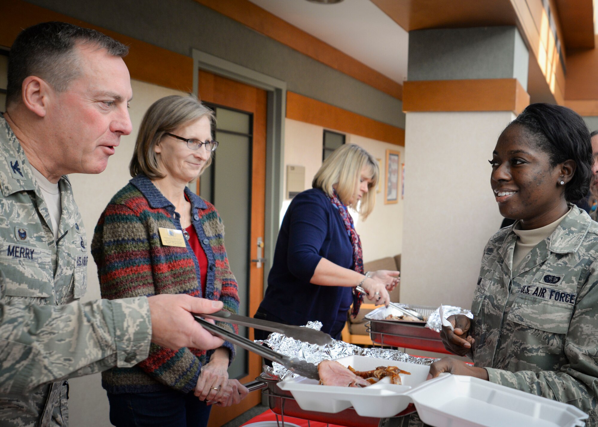 Col. Dan Merry, Air Force Mortuary Affairs Operations commander, serves Senior Airman Chanelle Lamb, during a Thanksgiving meal at the Charles C. Carson Center for Mortuary Affairs, Dover Air Force Base, Del., Nov. 18, 2014. Lamb is a reservist from the 512th Memorial Affairs Squadron, Dover AFB, is deployed in support of the mortuary mission (U.S. Air Force photo/Capt. Ray Geoffroy) 