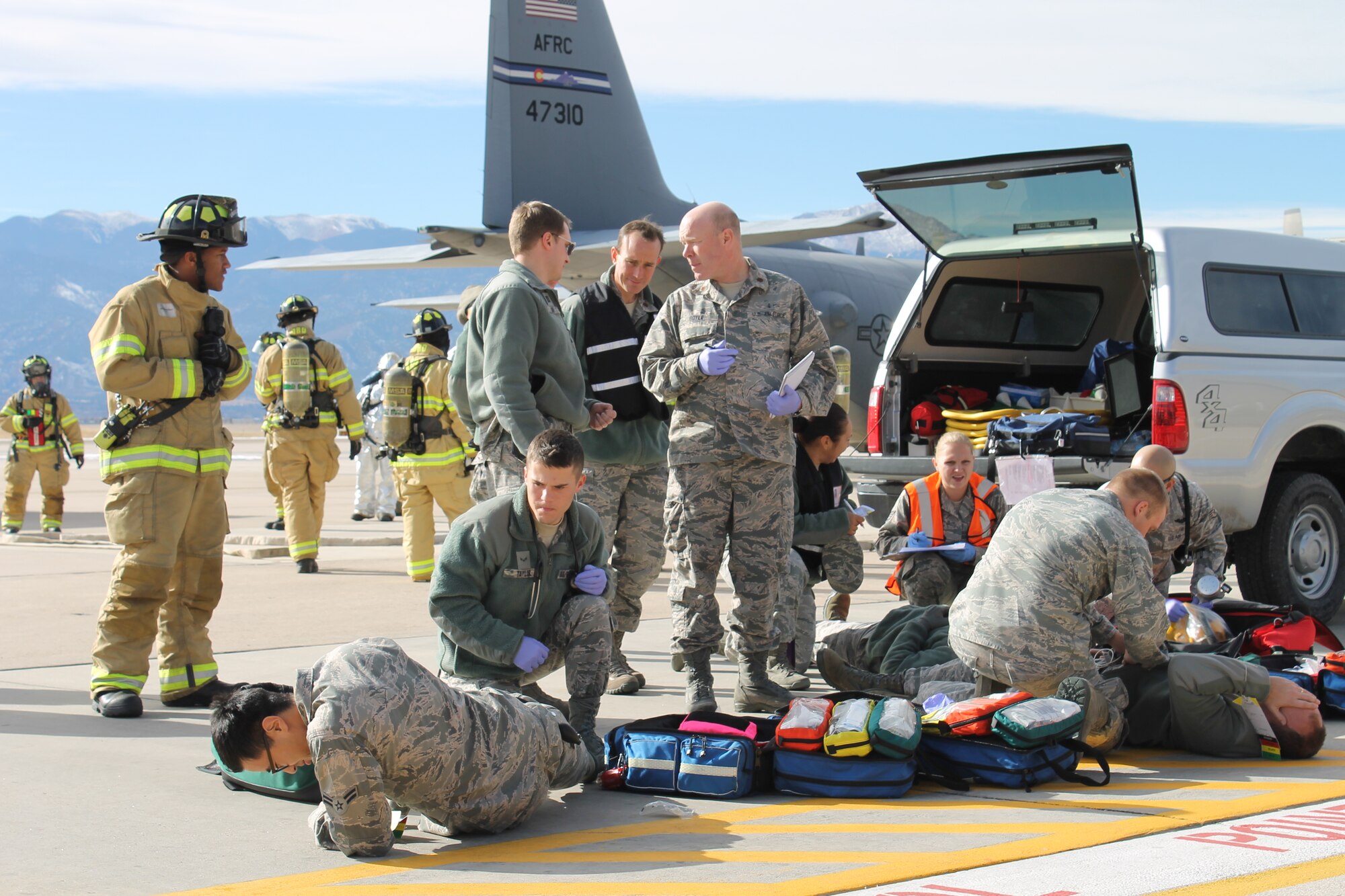 PETERSON AIR FORCE BASE, Colo. – Event evaluators (black safety vests) monitor the work of first responders treating ill C-130 Hercules crewmembers as part of the Condor Crest base exercise Nov. 18. Condor Crest is a quarterly exercise designed to test and evaluate base readiness for real-word events. (U.S. Air Force photo/Michael Golembesky)