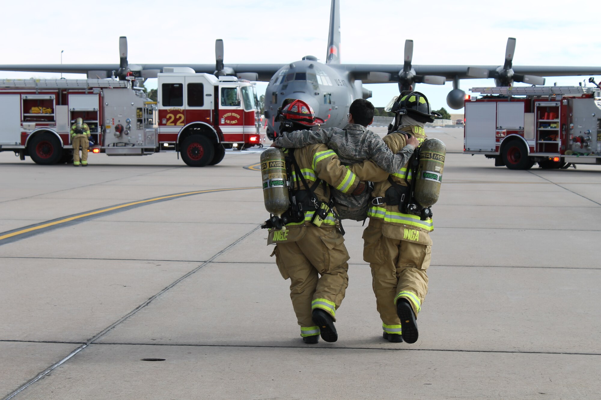 PETERSON AIR FORCE BASE, Colo. – Service members with the Peterson Air Force Base fire department carry an ill crewmember from a C-130 Hercules aircraft to a triage area during this quarter’s Condor Crest exercise on the base flight line Nov. 18. Condor Crest is a quarterly exercise designed to test and evaluate base readiness for real-word events. (U.S. Air Force photo/Michael Golembesky)