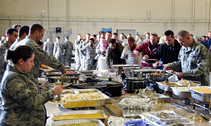 Airmen and families enjoy food during the 432nd Maintenance Group’s Thanksgiving celebration at Creech Air Force Base, Nevada, Nov. 21, 2014. The group hosted the event as a way to thank Airmen for their hard work, sacrifices, and dedication to the mission throughout the year. (U.S. Air Force photo by Tech. Sgt. Shad Eidson/released)