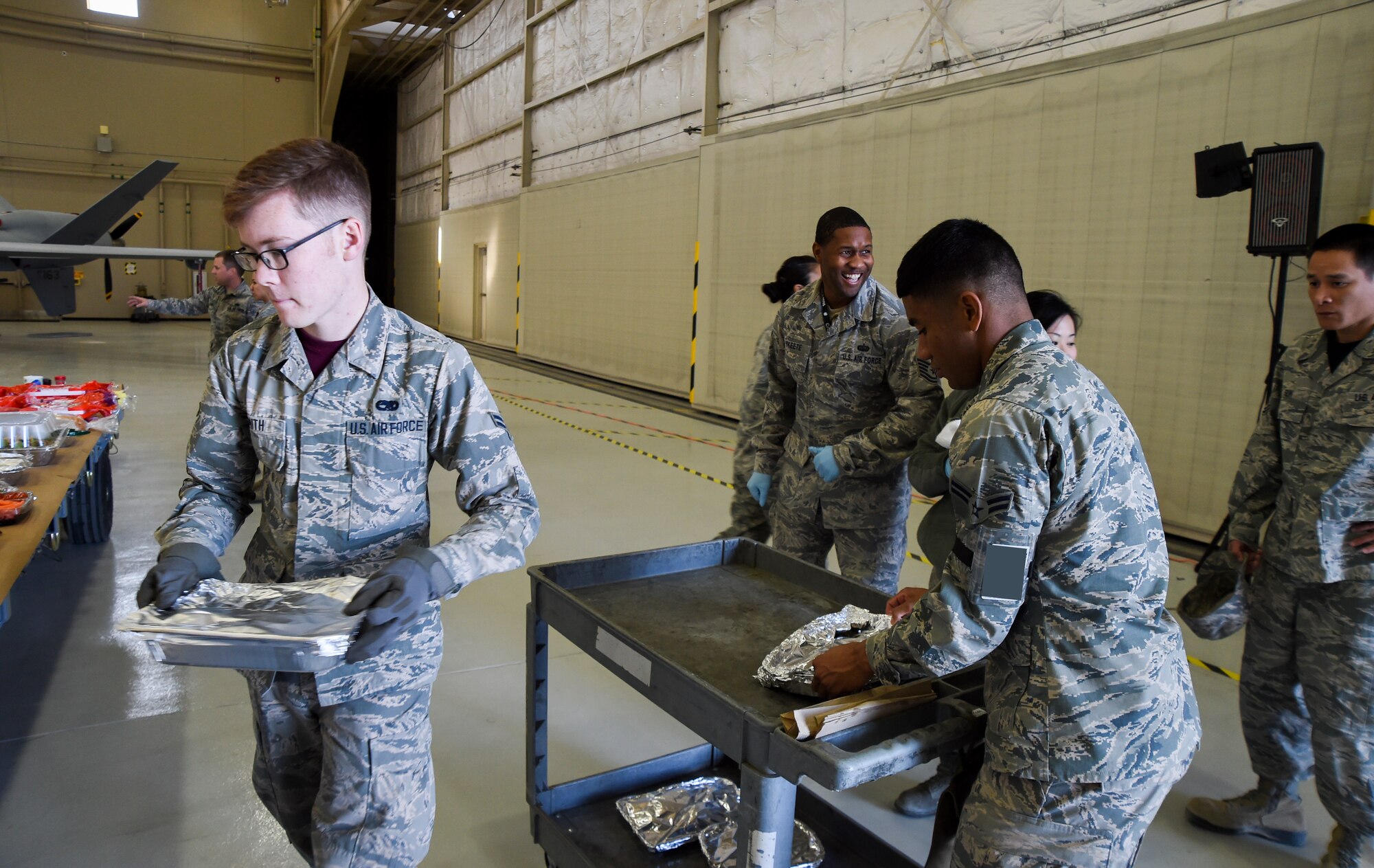 Airmen volunteer to set up food during the 432nd Maintenance Group’s Thanksgiving celebration at Creech Air Force Base, Nevada, Nov. 21, 2014. Approximately 40 volunteers supported the event, which provided Airmen and their families an opportunity to celebrate the holiday early. (U.S. Air Force illustration by Tech. Sgt. Shad Eidson/released)