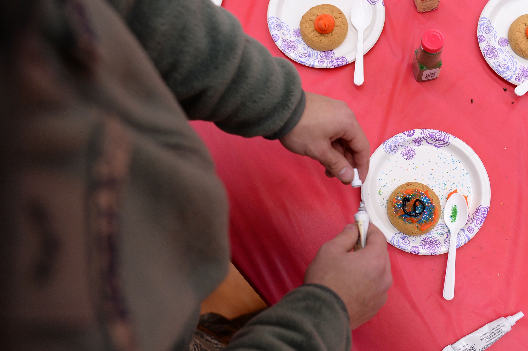 A U.S. Air Force Airman decorates a cookie during the Spangtacular Family Fall Festival Nov. 21, 2014, in the Skelton Memorial Fitness Center at Spangdahlem Air Base, Germany. The 52nd Fighter Wing Chapel hosted the event and provided free food, prizes and music. Volunteers from throughout the wing manned the activity booths. (U.S. Air Force photo by Staff Sgt. Daryl Knee/Released)