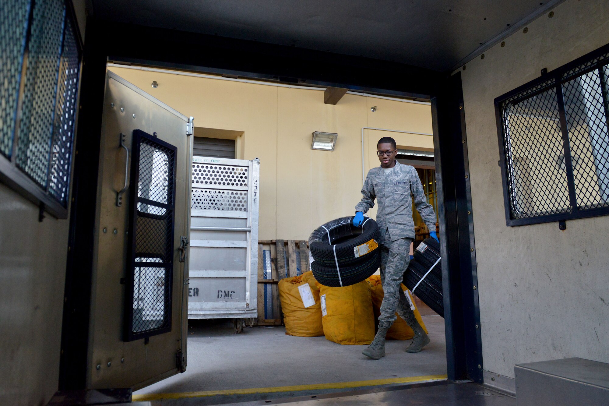 Airman 1st Class Kenneth Bell, 31st Communications Squadron postal clerk, carries tires to the back of a delivery truck, Nov. 25, 2014, at Aviano Air Base. The post office supports Team Aviano's mission by providing timely inbound and outbound postal services for more than 7,500 service members, dependents and civilians assigned to the installation. To ensure on-time delivery during the holiday season, volunteer postal workers help sort, pitch, process and hand out mail parcels to customers. (U.S. Air Force photo/Airman 1st Class Ryan Conroy) 