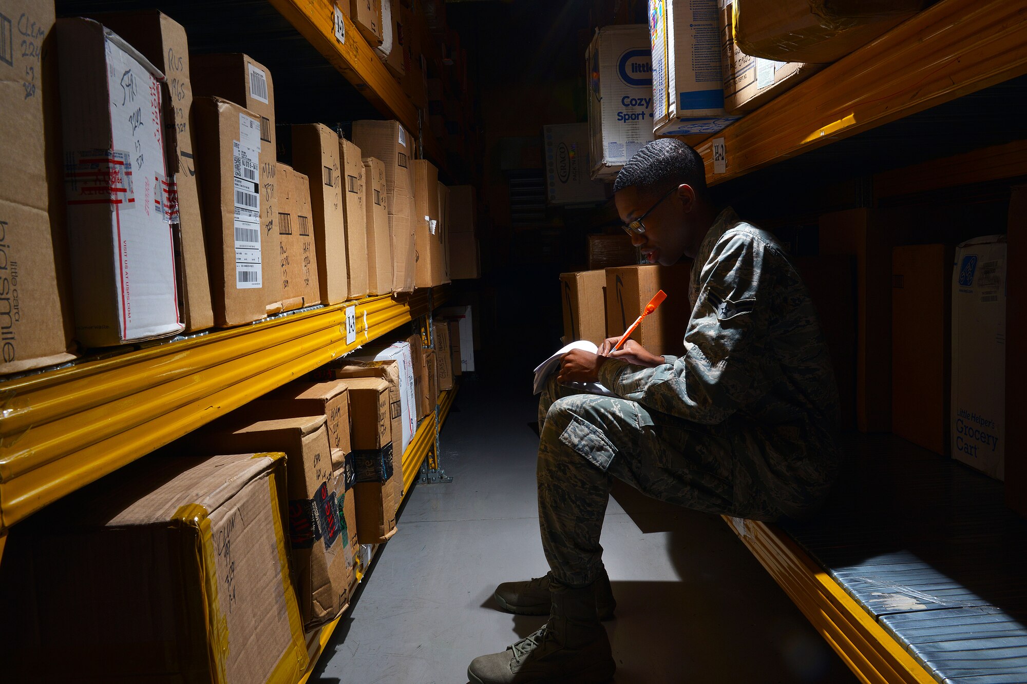 Airman 1st Class Kenneth Bell, 31st Communications Squadron postal clerk, handwrites notification of delivery for incoming boxes, Nov. 25, 2014, at Aviano Air Base, Italy. During the holiday season, volunteer postal workers are needed to ensure on-time delivery. Volunteers can expect to sort, pitch, process and hand out parcels to customers after an initial orientation briefing. To volunteer this season, U.S. citizens can sign up in person or on the 31 CS SharePoint website. (U.S. Air Force photo/Airman 1st Class Ryan Conroy) 