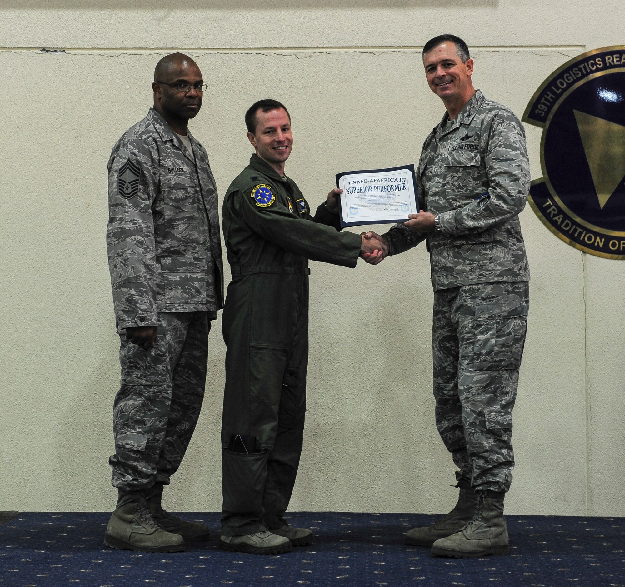 Lt. Col. Kyle Wilson, 39th Operation Support Squadron commander, accepted a superior performer award on behalf of Tech. Sgt. Benjamin Green, 39th OSS NCO in charge of intelligence, at the Unit Effectiveness Inspection out brief Nov. 24, 2014, Incirlik Air Base, Turkey. Green won for his outstanding individual performances during the UEI and was one of four individuals recognized during the event. (U.S. Air Force photo by Airman Cory W. Bush/Released)