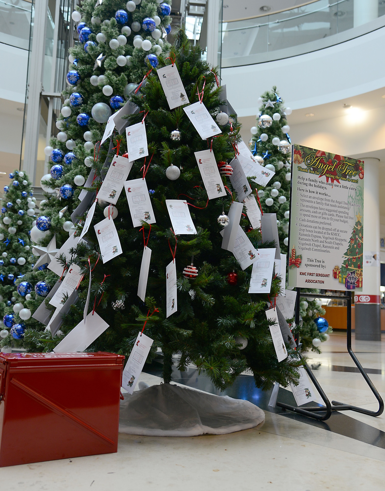 A tree, sign and donation collection box for the 2014 Angel Tree program sit in the middle of the Kaiserslautern Military Community Center at Ramstein Air Base, Germany, Nov. 17, 2014. Angel Tree is an annual program led by the Kaiserslautern Military Community First Sergeant Council to help provide financial relief to military families during the holiday season. (U.S. Air Force photo/Senior Airman Timothy Moore)