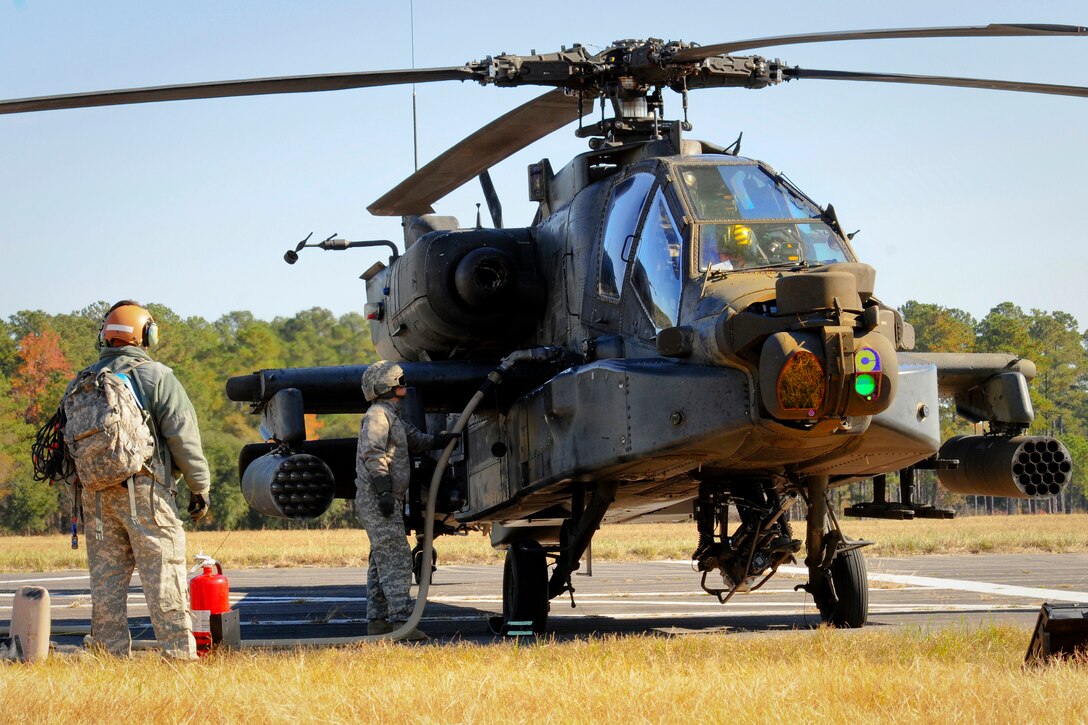 Army Sgt. Britany DeMichele, center, refuels an AH-64D Apache helicopter at the forward arming refueling point during exercise Carolina Thunder 14 on McEntire Joint National Guard Base in Eastover, S.C., Nov. 15, 2014. DeMichele is a petroleum supply specialist assigned to the North Carolina Army National Guard's 1st Battalion, 130th Attack Reconnaissance Battalion.