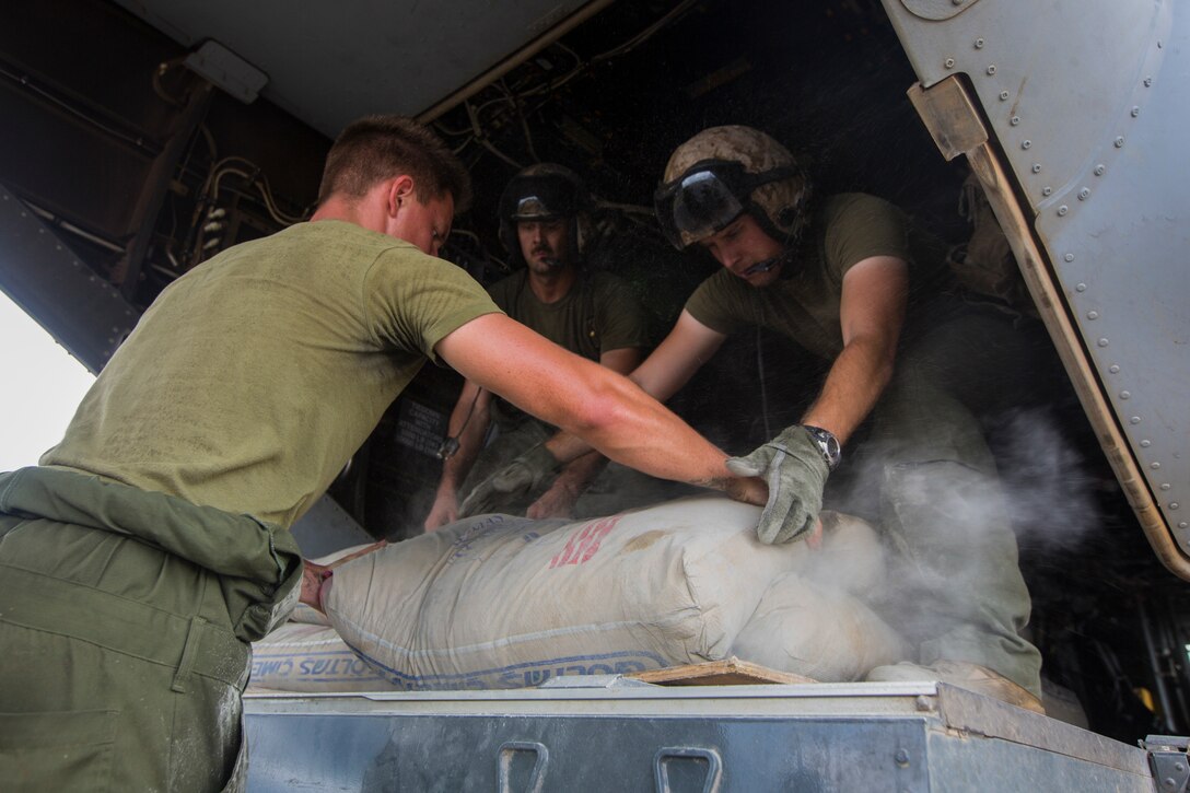 U.S. Marines with SPMAGTF Crisis Response - Africa load bags of concrete, that will be used by local and international health organizations to build Ebola Treatment Units, into an MV-22B Osprey during Operation United Assistance in Monrovia, Liberia, Nov. 21, 2014. United Assistance is a Department of Defense operation to provide command and control, logistics, training, and engineering support to U.S. Agency for International Development- led efforts to contain the Ebola virus outbreak in West African nations. (U.S. Marine Corps photo by Lance Cpl. Andre Dakis/ SPMAGTF-CR-AF Combat Camera/Released)