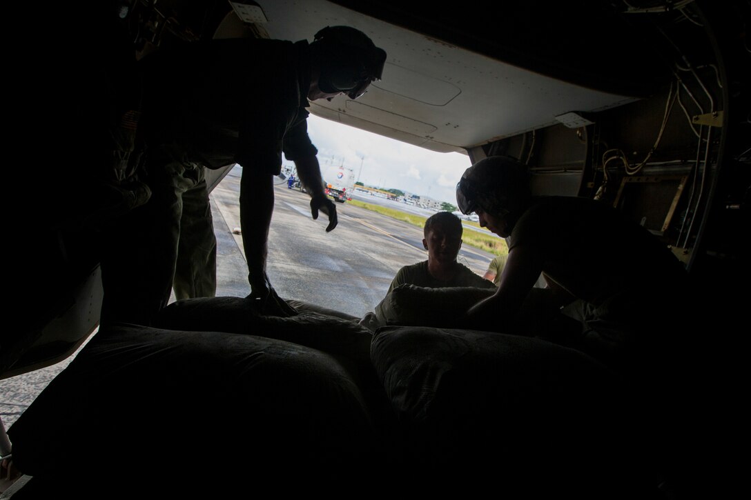 U.S. Marines with SPMAGTF Crisis Response - Africa load bags of concrete, that will be used by local and international health organizations to build Ebola Treatment Units, into an MV-22B Osprey during Operation United Assistance in Monrovia, Liberia, Nov. 21, 2014. United Assistance is a Department of Defense operation to provide command and control, logistics, training, and engineering support to U.S. Agency for International Development- led efforts to contain the Ebola virus outbreak in West African nations. (U.S. Marine Corps photo by Lance Cpl. Andre Dakis/ SPMAGTF-CR-AF Combat Camera/Released)
