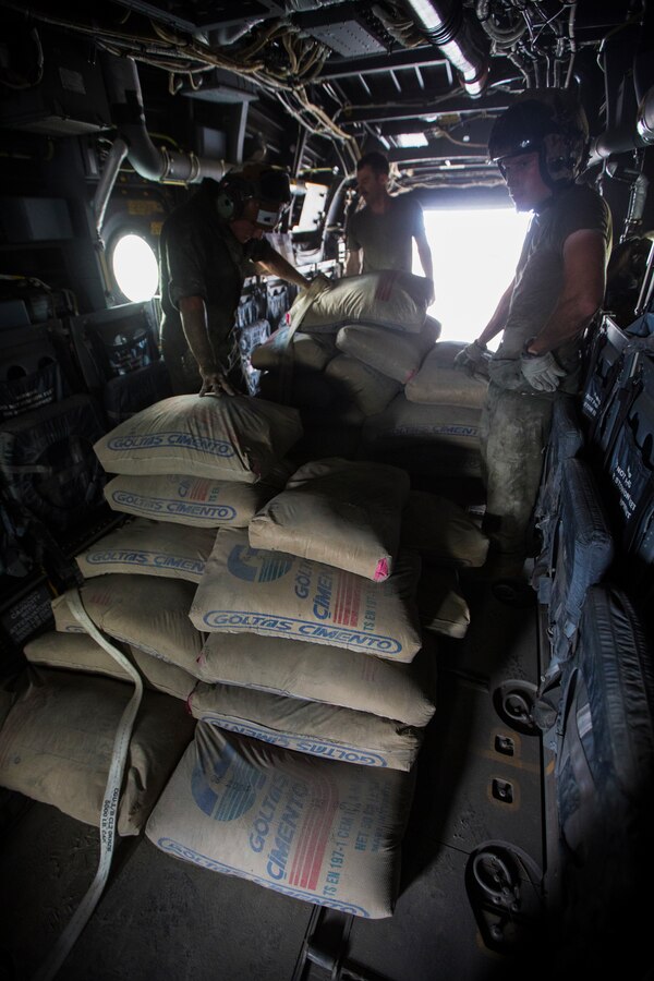 U.S. Marines with SPMAGTF Crisis Response - Africa load bags of concrete, that will be used by local and international health organizations to build Ebola Treatment Units, into an MV-22B Osprey during Operation United Assistance in Monrovia, Liberia, Nov. 21, 2014. United Assistance is a Department of Defense operation to provide command and control, logistics, training, and engineering support to U.S. Agency for International Development- led efforts to contain the Ebola virus outbreak in West African nations. (U.S. Marine Corps photo by Lance Cpl. Andre Dakis/ SPMAGTF-CR-AF Combat Camera/Released)