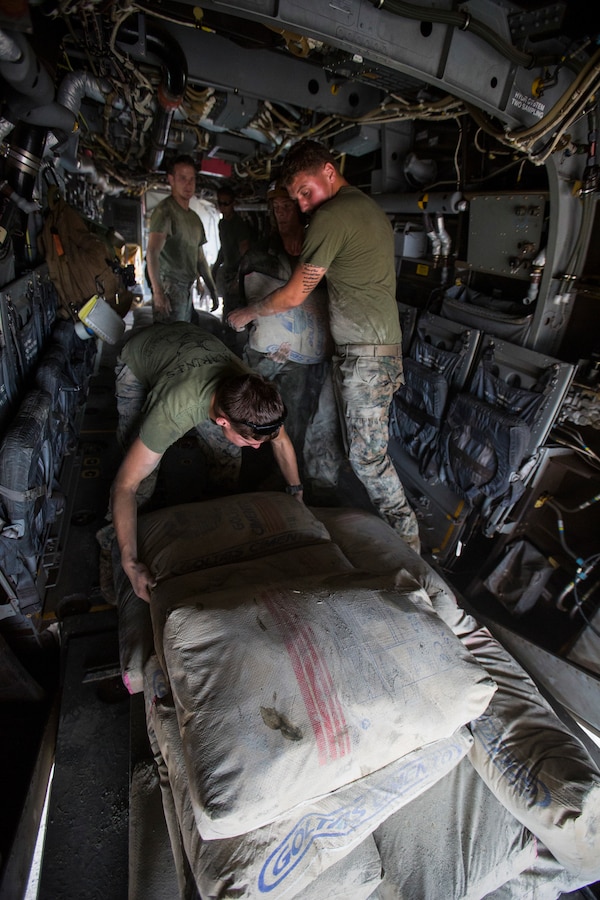 U.S. Marines with SPMAGTF Crisis Response - Africa load bags of concrete, that will be used by local and international health organizations to build Ebola Treatment Units, into an MV-22B Osprey during Operation United Assistance in Monrovia, Liberia, Nov. 21, 2014. United Assistance is a Department of Defense operation to provide command and control, logistics, training, and engineering support to U.S. Agency for International Development- led efforts to contain the Ebola virus outbreak in West African nations. (U.S. Marine Corps photo by Lance Cpl. Andre Dakis/ SPMAGTF-CR-AF Combat Camera/Released)