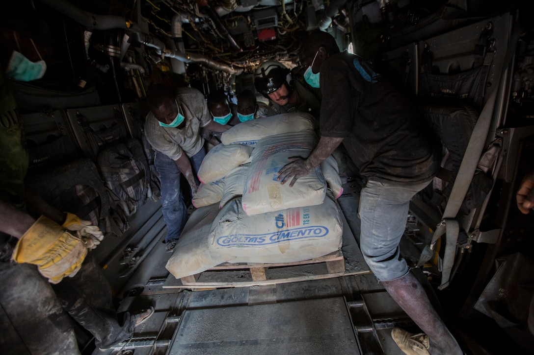 U.S. Navy Lt. Jeffery Fornadley, a flight surgeon with SPMAGTF Crisis Response – Africa, helps members of Samaritan's Purse, an international relief group, offload, from an MV-22B Osprey, bags of concrete that will be used to by health organizations to build Ebola Treatment Units, while in support of Operation United Assistance in Fish Town, Liberia, Nov. 21, 2014. United Assistance is a Department of Defense operation to provide command and control, logistics, training, and engineering support to U.S. Agency for International Development- led efforts to contain the Ebola virus outbreak in West African nations. (U.S. Marine Corps photo by Lance Cpl. Andre Dakis/SPMAGTF-CR-AF Combat Camera/Released)