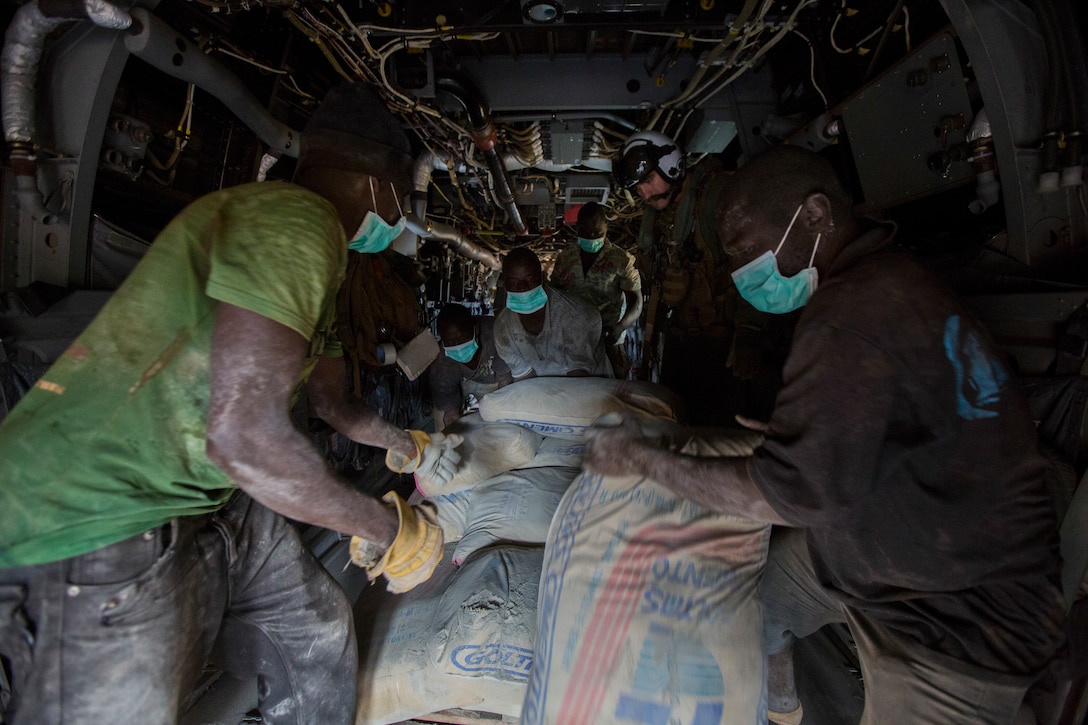 U.S. Navy Lt. Jeffery Fornadley, a flight surgeon with SPMAGTF Crisis Response – Africa, helps members of Samaritan's Purse, an international relief group, offload, from an MV-22B Osprey, bags of concrete that will be used to by health organizations to build Ebola Treatment Units, while in support of Operation United Assistance in Fish Town, Liberia, Nov. 21, 2014. United Assistance is a Department of Defense operation to provide command and control, logistics, training, and engineering support to U.S. Agency for International Development- led efforts to contain the Ebola virus outbreak in West African nations. (U.S. Marine Corps photo by Lance Cpl. Andre Dakis/SPMAGTF-CR-AF Combat Camera/Released)