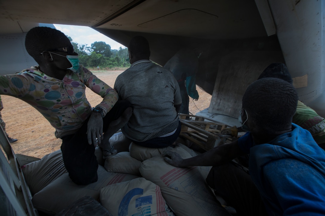Members of Samaritan's Purse, an international relief group, finish offloading bags of concrete from an MV-22B Osprey, assigned to SPMAGTF Crisis Response – Africa, that will be used to build Ebola Treatment Units while in support of Operation United Assistance in Monrovia, Liberia, Nov. 21, 2014. United Assistance is a Department of Defense operation to provide command and control, logistics, training, and engineering support to U.S. Agency for International Development- led efforts to contain the Ebola virus outbreak in West African nations. (U.S. Marine Corps photo by Lance Cpl. Andre Dakis/SPMAGTF-CR-AF Combat Camera/Released)