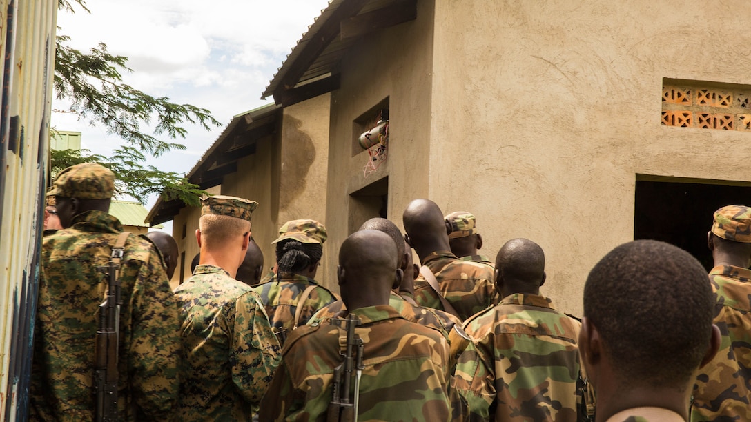 Explosive Ordnance Disposal Technicians discuss possible IED hiding places with members of the Uganda People’s Defense Force in Camp Singo, Uganda, Nov. 4, 2014. The EOD Technicians are part of a team of Marines and Sailors from SPMAGTF-Crisis Response-Africa working alongside the UPDF, helping hone their skills in countering-improvised explosive devices during a logistics and engineering training engagement. 