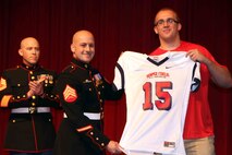 Grant Schmidt, an Offensive Tackle living in Sioux Falls, S.D. attending Roosevelt High School, is presented a jersey by Sgt. Ryan Fife, a recruiter from Sioux Falls, November 26. Schmidt was selected to play in the Marine Corps' Semper Fidelis All-American Bowl coming up this January. This rare opportunity is awarded to only those who the Marine Corps has determined best represent the core values of honor, courage and commitment. 