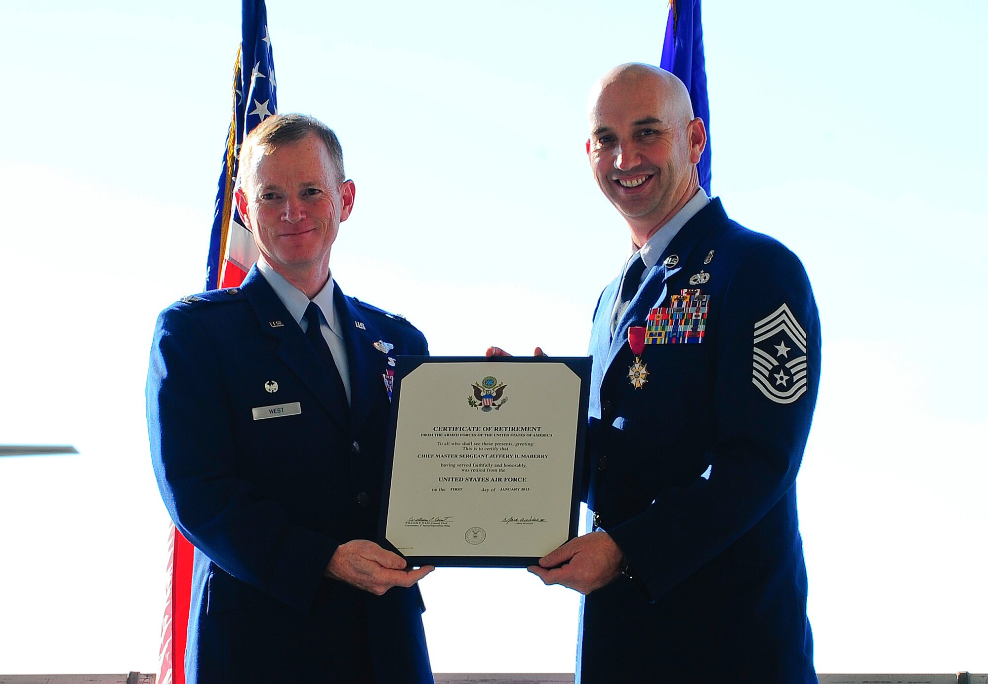 Col. Bill West, 1st Special Operations Wing commander, presents Chief Master Sgt. Jeff Maberry his retirement certificate at Hurlburt Field Fla., Nov. 21, 2014. Chief Maberry retired, after 26 years in the Air Force.