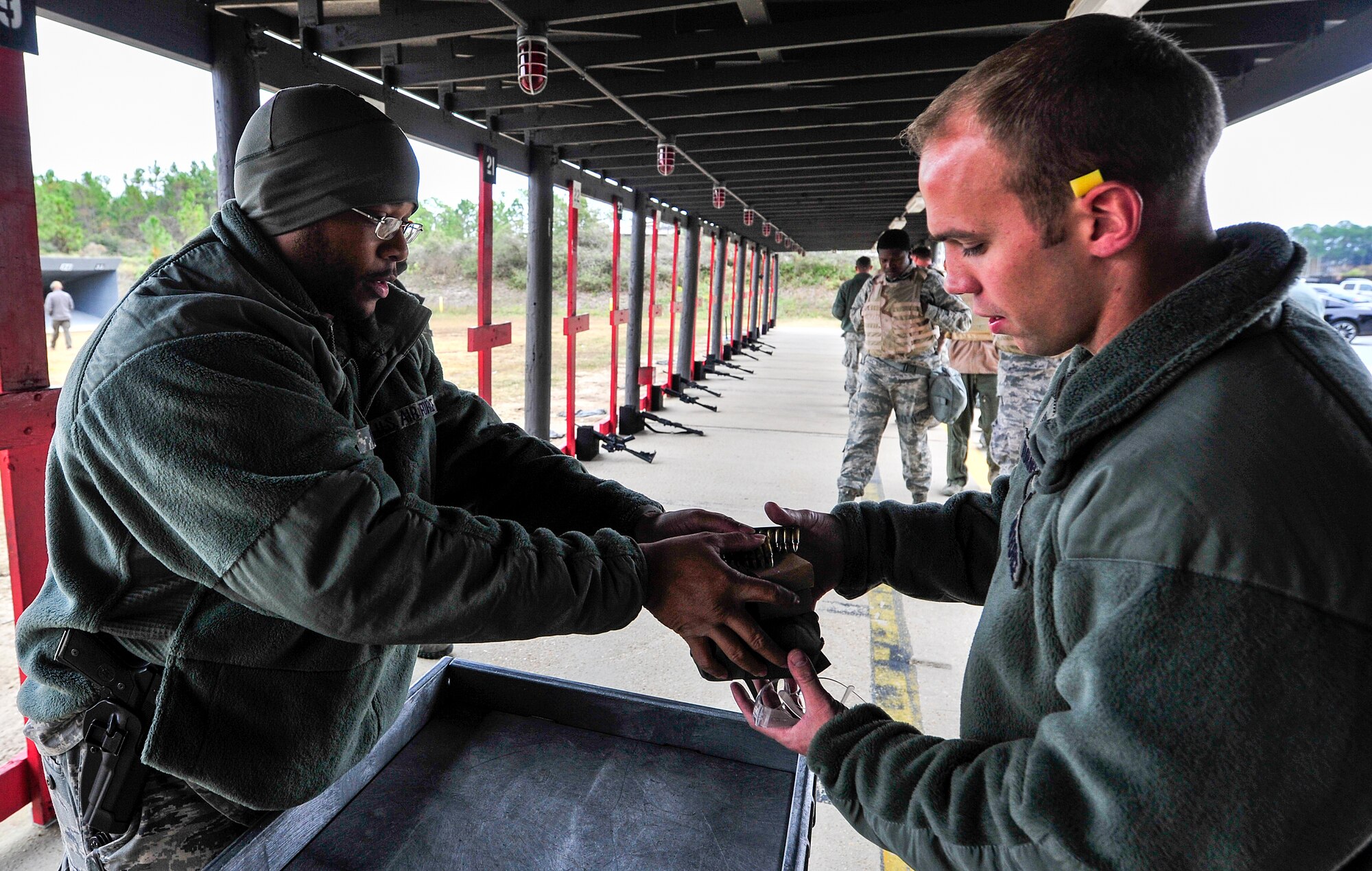 Staff Sgt. Dominique Moore, 1st Special Operations Security Forces Squadron Combat Arms Training and Maintenance instructor, hands out M4 rifle ammunition during small arms training at Hurlburt Field, Fla., Nov. 13, 2014. CATM instructors train and qualify Airmen on required weapons needed for deployments. (U.S. Air Force photo/Airman 1st Class Jeff Parkinson)