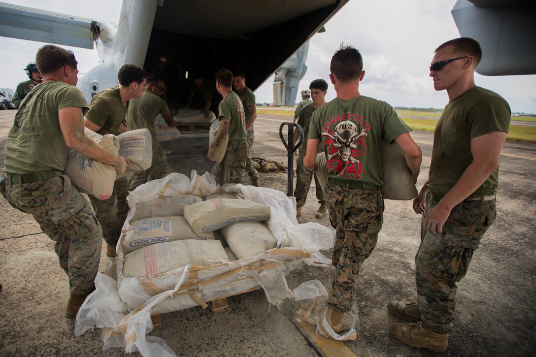 U.S. Marines with SPMAGTF Crisis Response - Africa load bags of concrete, that will be used by local and international health organizations to build Ebola Treatment Units, into an MV-22B Osprey during Operation United Assistance in Monrovia, Liberia, Nov. 21, 2014. United Assistance is a Department of Defense operation to provide command and control, logistics, training, and engineering support to U.S. Agency for International Development- led efforts to contain the Ebola virus outbreak in West African nations. (U.S. Marine Corps photo by Lance Cpl. Andre Dakis/ SPMAGTF-CR-AF Combat Camera/Released)