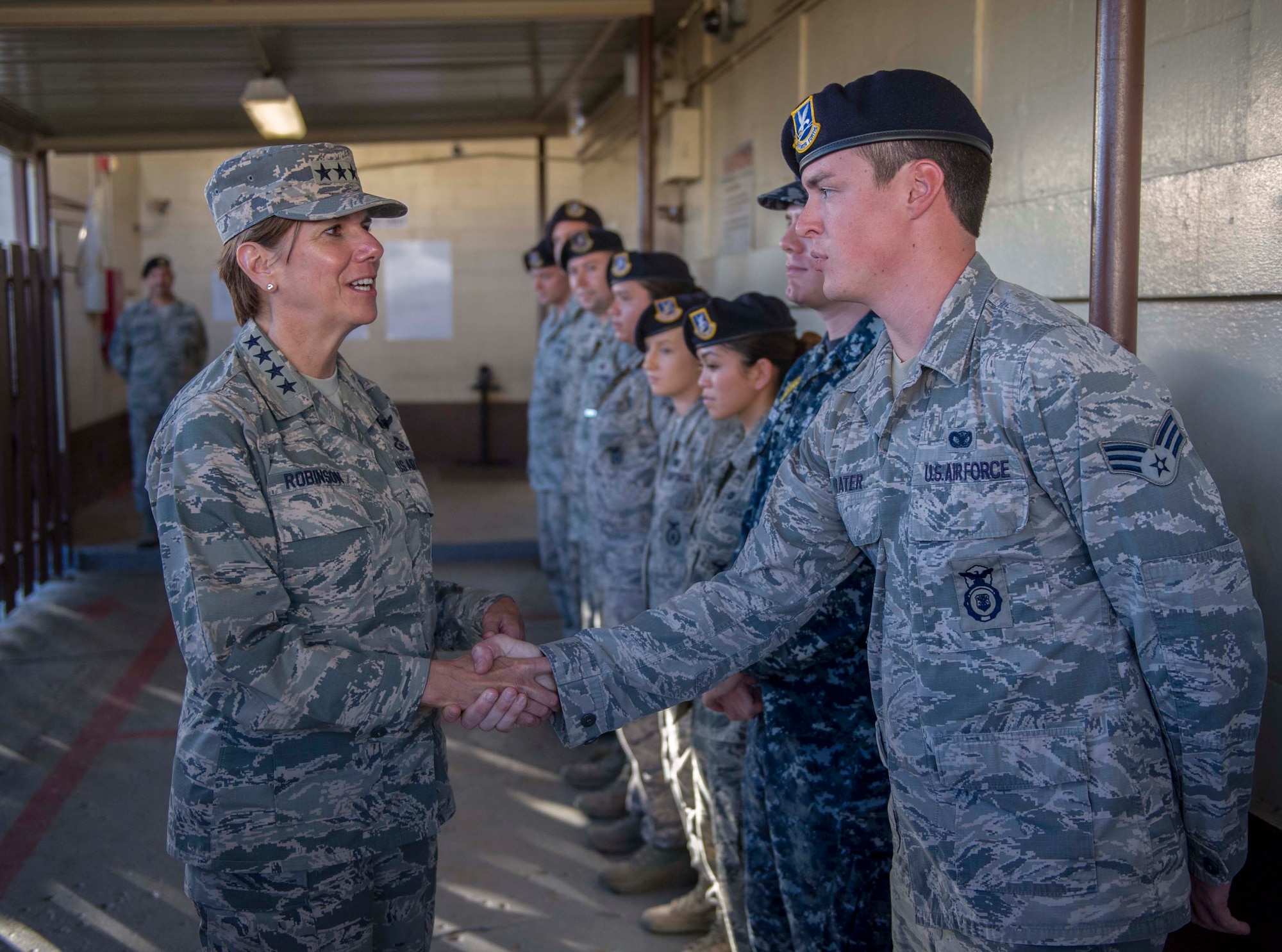 Gen. Lori Robinson, Pacific Air Forces commander, shakes hands with Senior Airman Cory Prater, 647th Security Forces Squadron, during her visit to the squadron on Joint Base Pearl Harbor-Hickam, Hawaii, Nov. 25, 2014. General Robinson conducted her initial base tour to gain a better understanding of unit readiness and base capabilities and services while interacting with Airmen face-to-face. (U.S. Air Force photo by Tech. Sgt. Terri Paden/RELEASED)