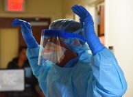 Lt. Col. John Weatherwax, 341st Medical Operations Squadron pediatric nurse, suits up with the proper safety attire before caring for a simulated Ebola patient during an exercise at the Malmstrom Air Force Base Clinic Nov. 25. During the exercise, Weatherwax acted as the primary caregiver for the simulated Ebola patient and had to be in full protective gear. (U.S. Air Force photo/Airman 1st Class Collin Schmidt)