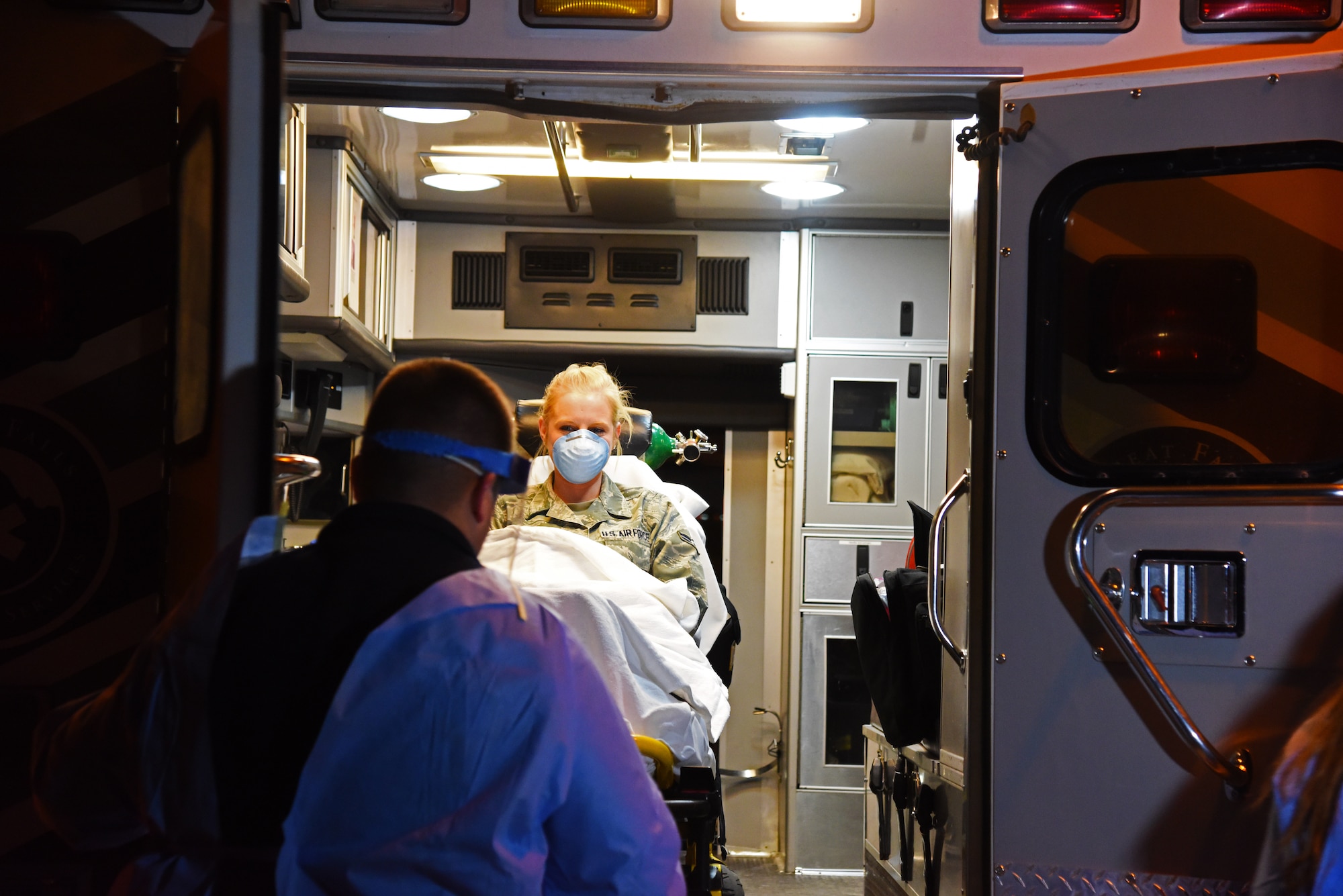 Airman 1st Class Kaitlyn Arteaga, 341st Medical Operations Squadron physical therapy technician, is loaded into the back of an ambulance by a Benefis Health System emergency responder during an Ebola exercise at the Malmstrom Air Force Base Clinic Nov. 25. The exercise was performed in conjunction with Great Falls Emergency Services, Great Falls Fire/Rescue, the Great Falls Clinic, Benefis Health System and the Cascade City-County Health Department. (U.S. Air Force photo/Airman 1st Class Collin Schmidt) 