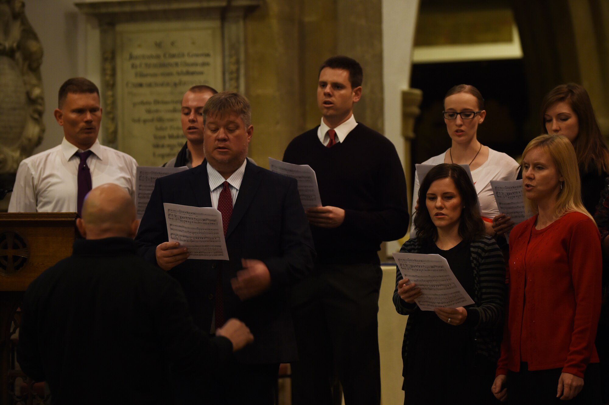 U.S. Air Force Col. Douglas Mellars, 422nd Air Base Group commander, front-left, conducts a chorus during a pre-service concert at St. Edburg's Church, Bicester, England, Nov. 26, 2014. The concert was part of the annual British-American Ecumenical Thanksgiving Service. (U.S. Air Force photo by Staff Sgt. Jarad A. Denton/Released)