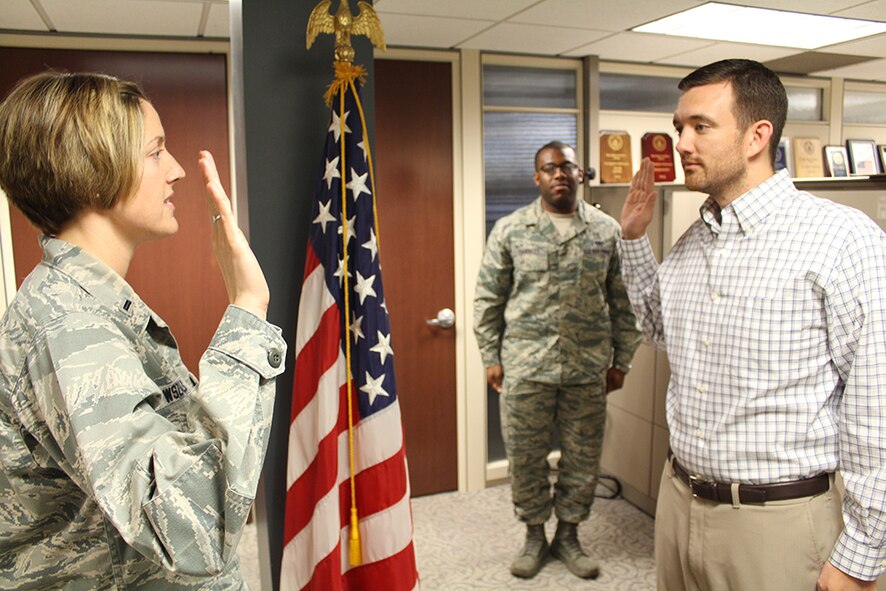 First Lt. Liz Wszalek, 932nd executive officer, reads the oath of enlistment to Tech. Sgt. 
Aaron McLaughlin, who will be rejoining the military to work with refuelers.  His recruiter, Staff Sgt. Keith Garrett, assisted him with coordination and paperwork to make the overall process smoother.  (U.S. Air Force photo/Maj. Stan Paregien)