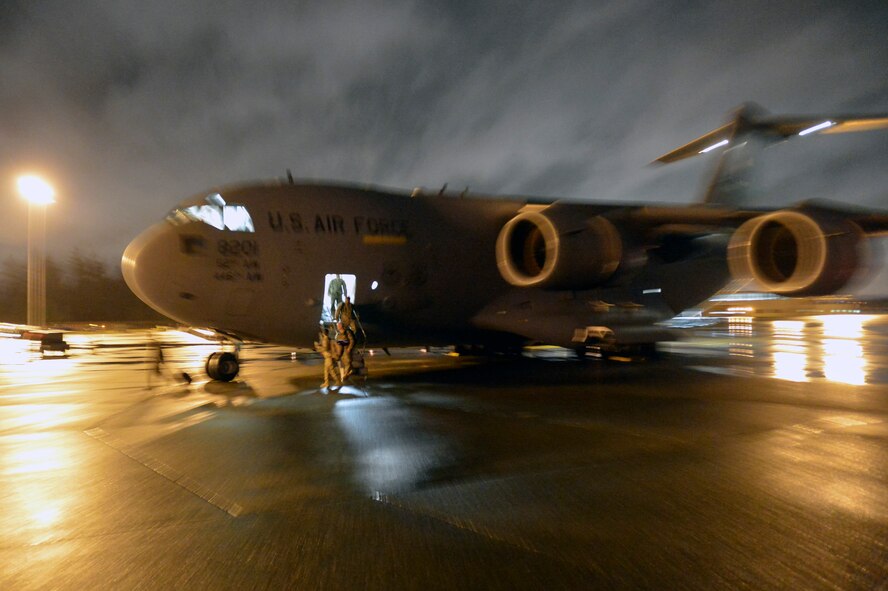 Airmen, Soldiers, Marines, Sailors and civilians supporting Operation United Assistance deplane a C-17 Globemaster III Nov. 25, 2014, at Joint Base Lewis-McChord, Wash. According to the Chairman of the Joint Chiefs of Staff Instruction, all DoD service members will undergo a 21-day controlled monitoring program upon return from deployment to West Africa. (U.S. Air Force photo/Staff Sgt. Russ Jackson)