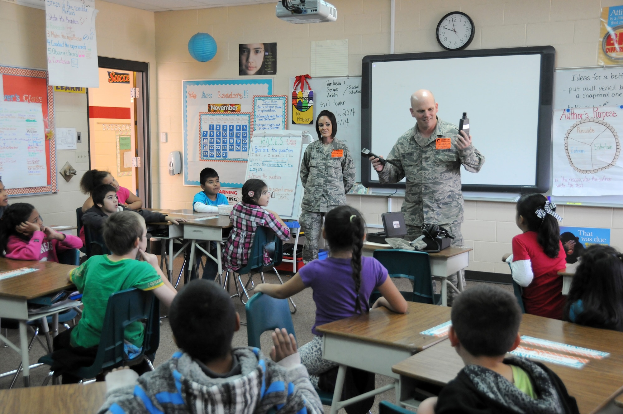 Senior Airman Kristen Grimm and Master Sgt. Greg Qualls present vehicle maintenance equipment to students at during career day at Sutton Elementary, Nov. 6, 2014. Grimm and Qualls are assigned to the 188th Logistics Readiness Squadron. The event was part of the Fort Smith Public School Partners in Education program. (U.S. Air National Guard photo by Airman 1st Class Cody Martin/Released)