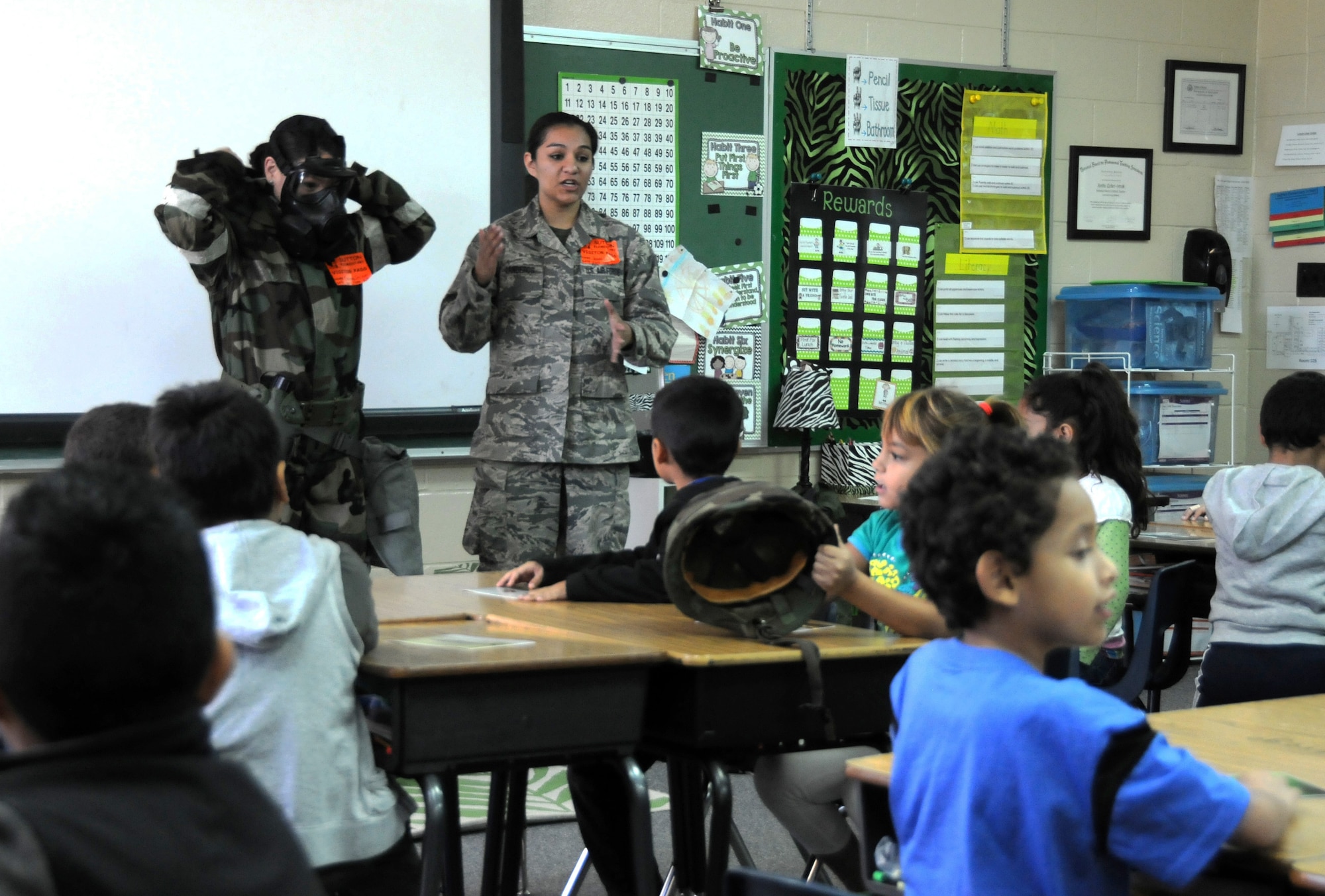 Staff Sgt. Caressa Soriano, left, and Staff Sgt. Hannah Dickerson educate students at Sutton Elementary on mission oriented protective posture gear during a career day presentation. Nov. 6, 2014, in Fort Smith, Ark. Soriano is assigned to the 188th Logistics Readiness Squadron and Dickerson is assigned to the 188th Wing Public Affairs Office. The event was part of the Fort Smith Public School Partners in Education program. (U.S. Air National Guard photo by Airman 1st Class Cody Martin/Released)