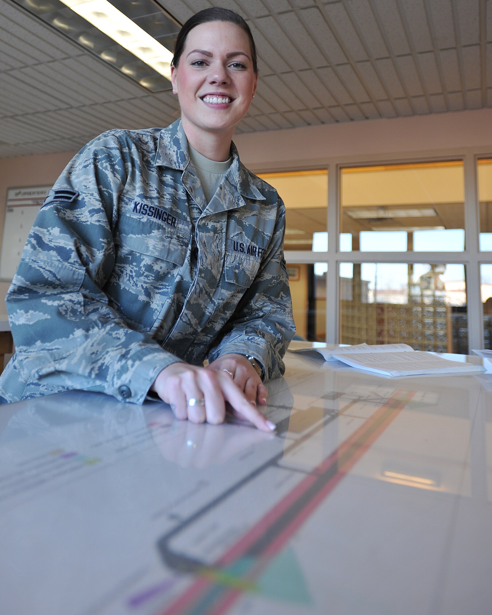 Airman 1st Class Jordan Kissinger, 319th Operations Support Squadron airfield management shift lead, points at a location on the traffic patterns and airfield diagram in the flight planning room on Nov. 24,2014 on Grand Forks Air Force Base, N.D. Kissinger was named the 319th Air Base Wing Warrior of the Week for the fourth week of November 2014. (U.S. Air Force photo/Senior Airman Xavier Navarro)