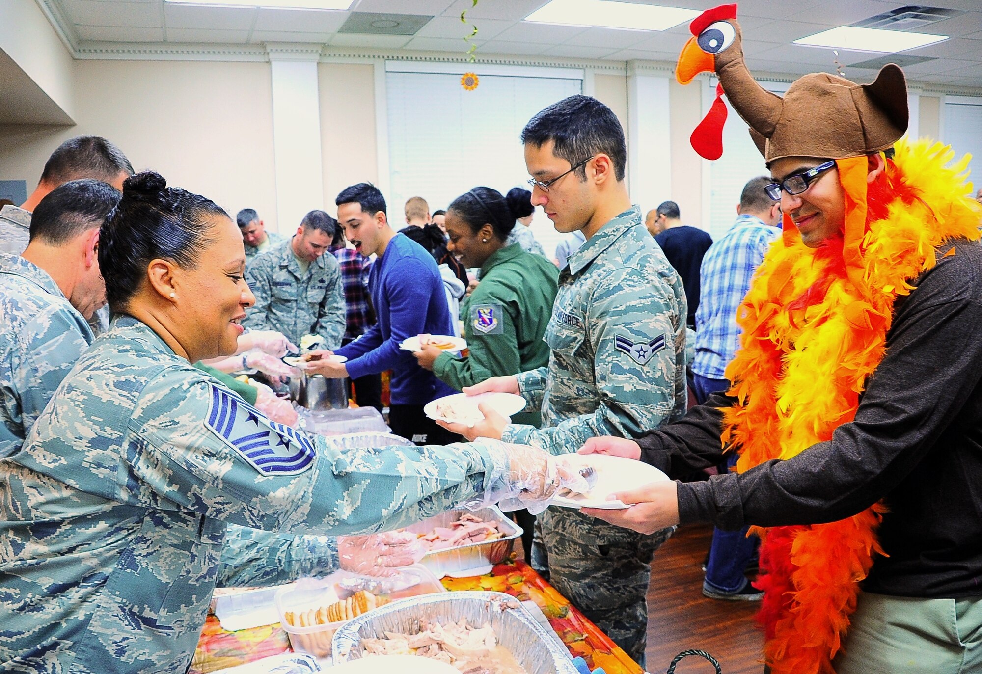Chief Master Sgt. Rita Felton, 14th Flying Training Wing Command Chief, serves turkey to Airman 1st Class Samuel Chavez, 14th Communication Squadron Client Service Technician, at the November dorm dinner Nov. 20 in the chapel annex. Served at Dormsgiving were turkey, ham, mashed potatoes, macaroni and cheese, pumpkin pie and many other foods often served at Thanksgiving. (U.S. Air Force photo/Airman John Day)