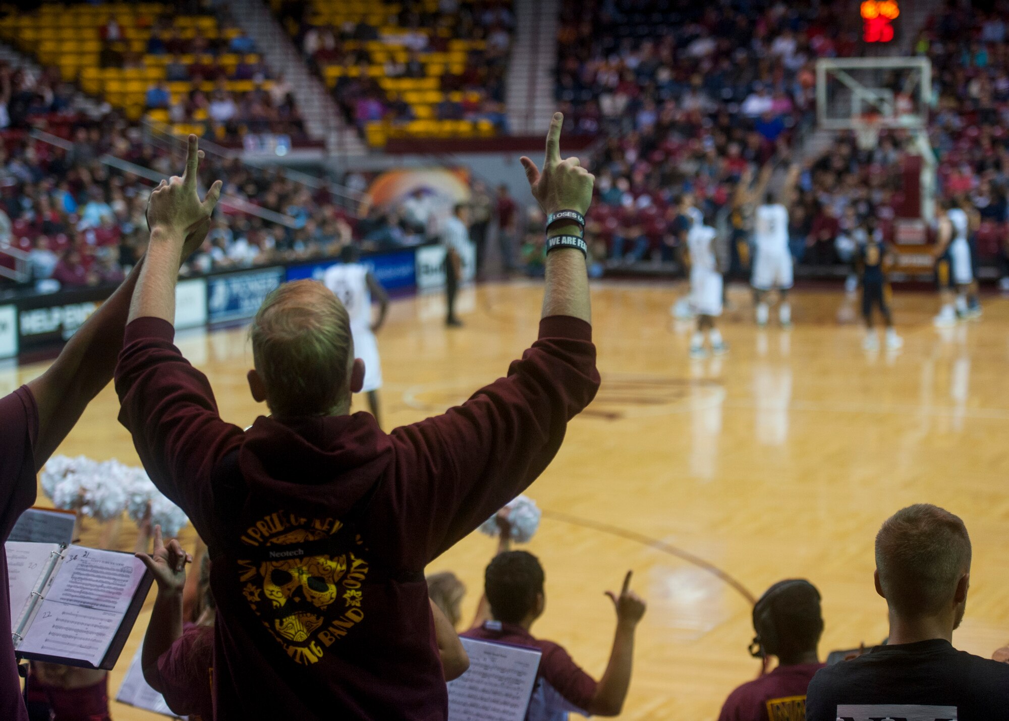 New Mexico State Aggies student section hold up their hands for luck at the Pan American Center in Las Cruces, N.M., Nov. 19. The Aggies compete in the Western Athletic Conference alongside several other schools in the region. Airmen can drive to the Pan American Center just an hour away from Holloman Air Force Base to enjoy the excitement of a live game atmosphere and to cheer on a team that’s appeared in the NCAA tournament the last three years running. (U.S. Air Force photo by Senior Airman Daniel E. F. Liddicoet/Released)
