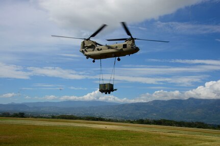 A CH-47 Chinook flies a container to the Warrior Ramp during air load and fly-away training on Soto Cano Air Base, Honduras, Nov. 25, 2014.  The cargo was delivered to the U. S. Southern Command Situational Assessment Team at the Warrior Ramp for employment in the day’s training event.  During the training members of the S-SAT received training on setting a Pre-Positioned Expeditionary Assistance Kit to help prepare the team respond efficiently to humanitarian assistance and disaster response situations throughout U.S. Southern Command’s area of responsibility.  The training focused on S-SAT familiarization, hands on training and a fly-away event between JTF-Bravo S-SAT personnel, Army Forces Battalion, and 1-228th Aviation Regiment in preparation for an upcoming exercise.  (U.S. Air Force photo/Tech. Sgt. Heather Redman)