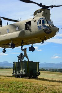 U.S. Army Spcs. Jack Wood and David Swain, assigned to the Army Forces Battalion, attach a container to a CH-47 Chinook during air load and fly-away training on Soto Cano Air Base, Honduras, Nov. 25, 2014.  The cargo was delivered to the U. S. Southern Command Situational Assessment Team at the Warrior Ramp for employment in the day’s training event.  During the training members of the S-SAT received training on setting up a Pre-Positioned Expeditionary Assistance Kit to help prepare the team respond efficiently to humanitarian assistance and disaster response situations throughout U.S. Southern Command’s area of responsibility.  The training focused on S-SAT familiarization, hands on training and a fly-away event between JTF-Bravo S-SAT personnel, Army Forces Battalion, and 1-228th Aviation Regiment in preparation for an upcoming exercise.  (U.S. Air Force photo/Tech. Sgt. Heather Redman)