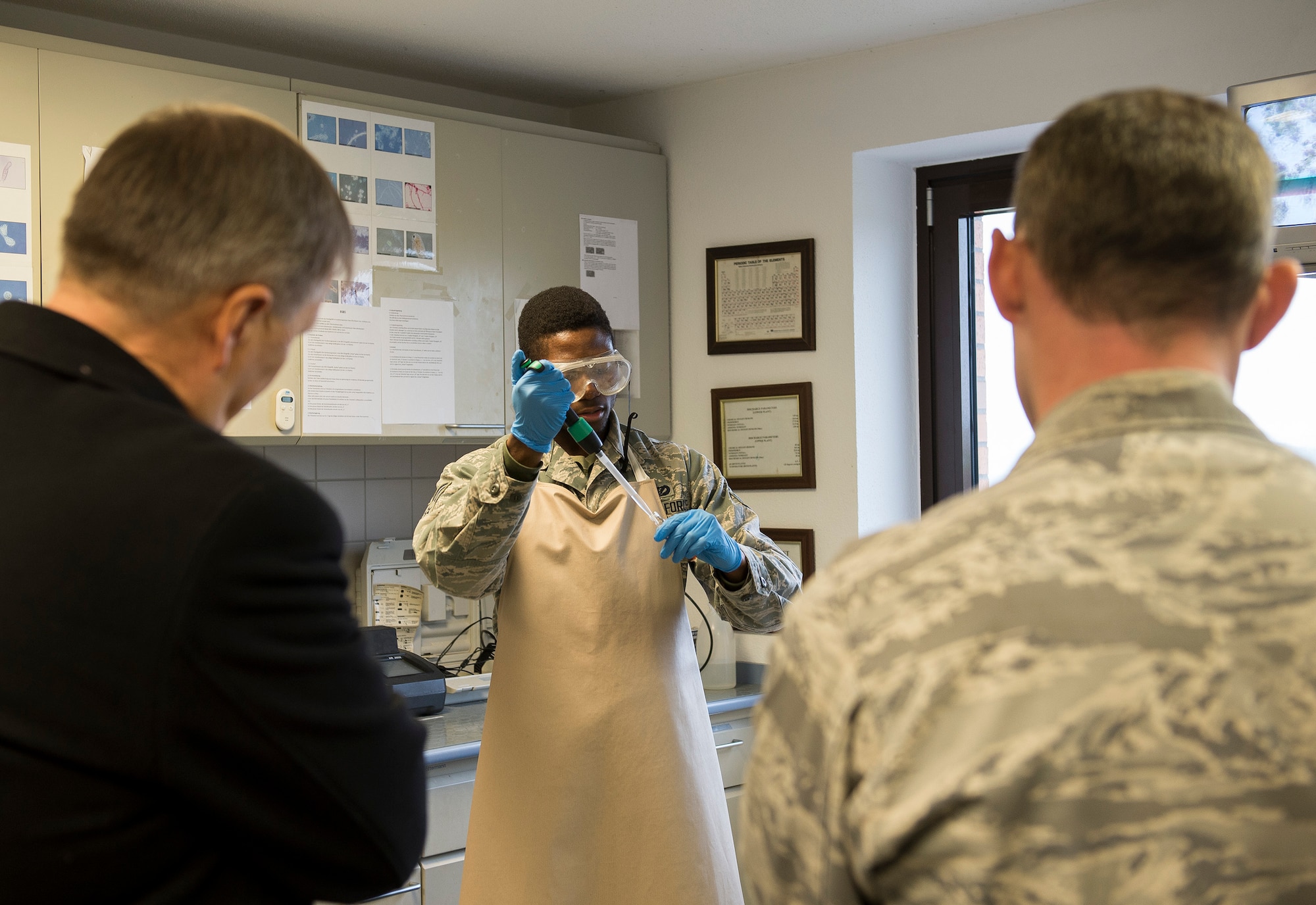 Dr. Ulrich Kleemann, SGD-Nord president, left, and U.S. Air Force Lt. Col. Christopher Meeker, 52nd Civil Engineer Squadron commander, right, watch as U.S. Air Force Senior Airman Darius Richardson, 52nd CES fuel and water systems maintenance journeyman, conducts laboratory operations Nov. 20, 2014, at the waste water plant near Spangdahlem Air Base, Germany. Kleemann toured the base to discuss the wing’s continuing commitment to responsible stewardship of the environment and prospects for partnering with SGD-Nord, the environmental protection organization for the Rhineland-Pfalz region. (U.S. Air Force photo by Staff Sgt. Chad Warren/Released)