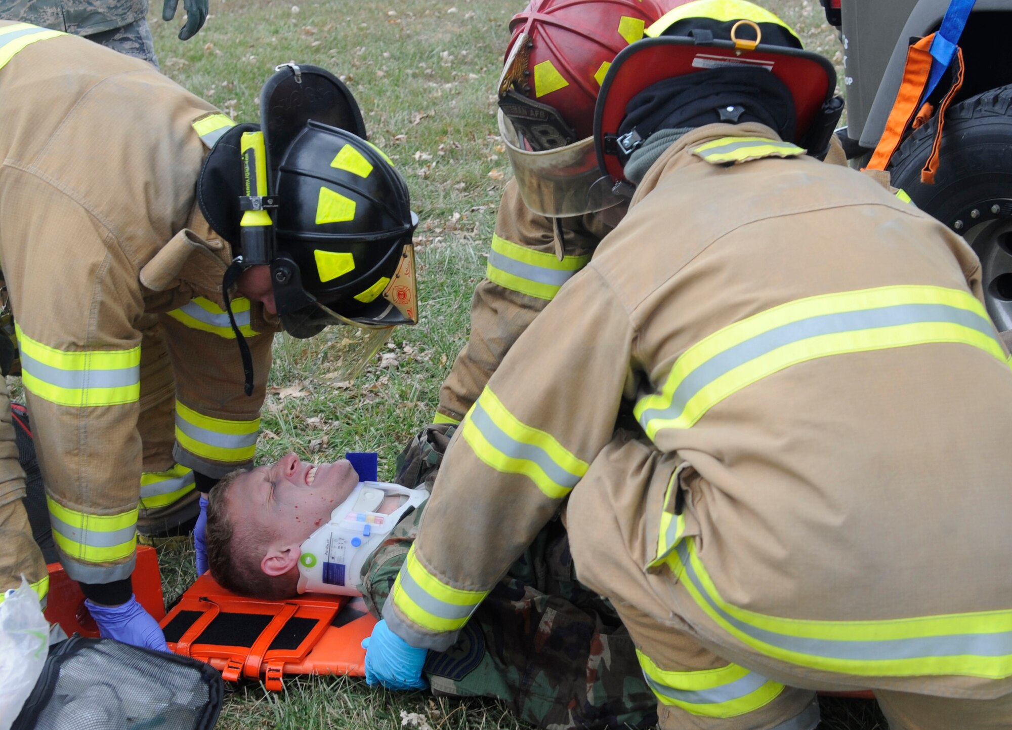 WHITEMAN AIR FORCE BASE, MO—Senior Airman Jacob Dietmyer, Mr. Emanuel Villegas and Staff Sgt. Dan Baumgartner, 509th Civil Engineer Squadron fire emergency medical service, prepares to lift the patient to the ambulance to be transferred for hospital care during a motor vehicle accident exercise at Whiteman Air Force Base, Mo., Nov. 21, 2014. The 509th Medical Group initiates an exercise with base and local emergency responders to ensure response time, treatment of patients, and coordination of patient transport. (U.S. Air Force photo by Staff Sgt. Alexandra M. Boutte/Released)